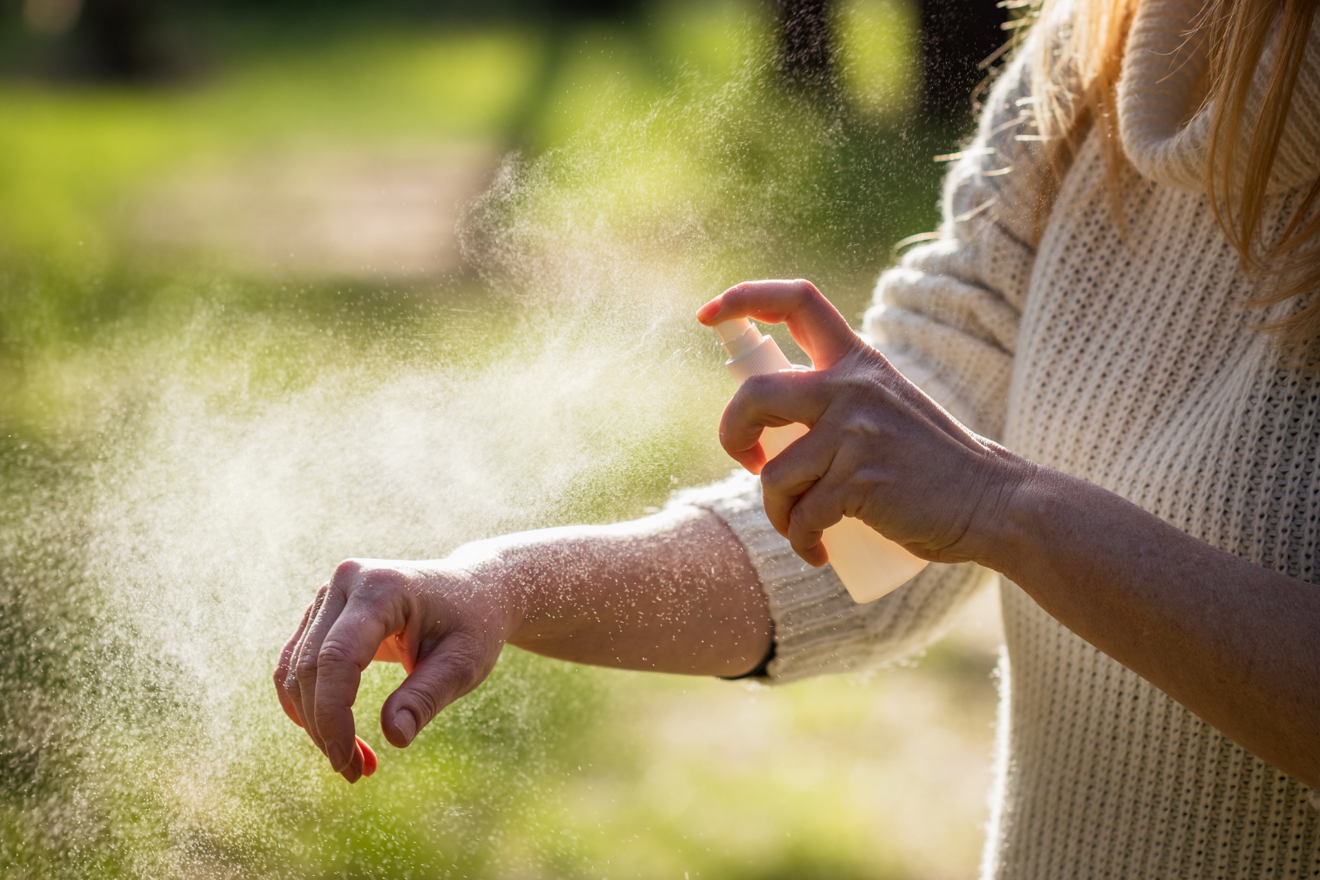 Woman applying repellant to get rid of mosquitoes